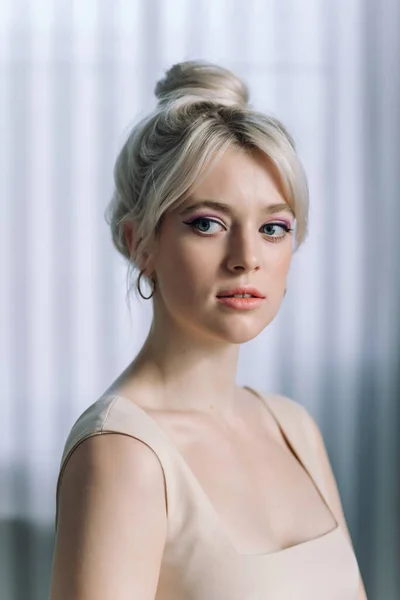 Yan bakan güzel sarışın bir kadının stüdyo portresini kapat. Mavi gözler, genç ve narin.