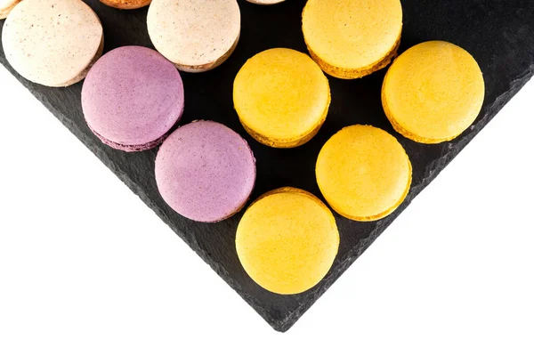 Les macarons sont disposés sur une ardoise noire en rangées magnifiquement colorées. — Photo