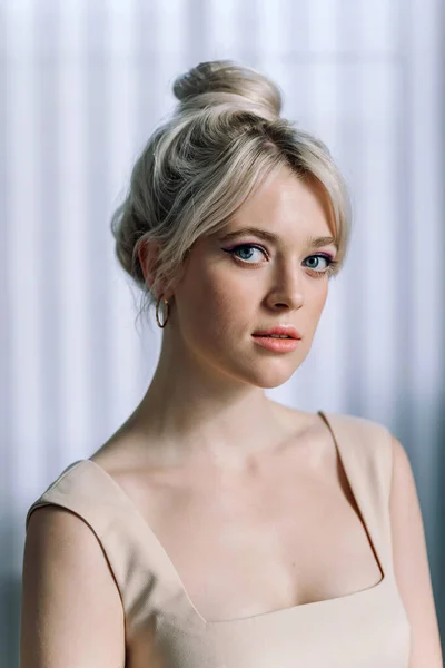 Güzel sarışın bir kadının stüdyo portresini kapat ve kameraya ağzı açık bak. Mavi gözler, genç ve narin.