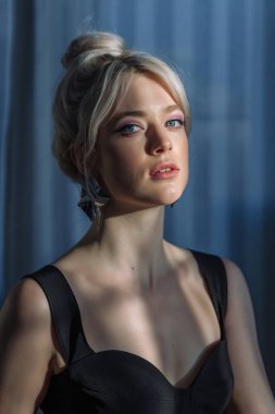 Siyah bluzlu güzel sarışın bir kadının stüdyo portresini kapat. Takma diş.