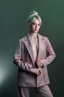 Seksi genç bir sarışın, çıplak bir vücut giysisi giymiş bir ceket..