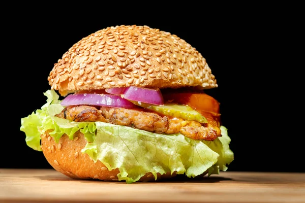 Burger mit roten Zwiebeln, Fleisch, Tomaten, Ketchup. Sesambrötchen, großer Salat. — Stockfoto