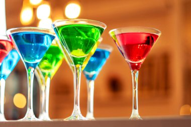 Bar tezgahında çeşitli alkollü içecekler servis ediliyor. Gözlüklü renkli içecekler..