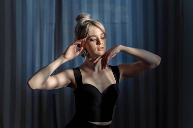 Siyah bluzlu güzel bir sarışının stüdyo portresi..