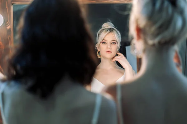 Сексуальная молодая блондинка смотрит в зеркало. — стоковое фото
