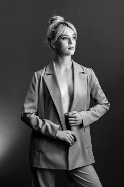 Seksi genç bir sarışın, çıplak bir vücut giysisi giymiş bir ceket..