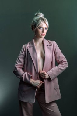 Seksi genç bir sarışın, çıplak bir bedenin üzerine giymiş bir ceket. Manken yana bakıyor..