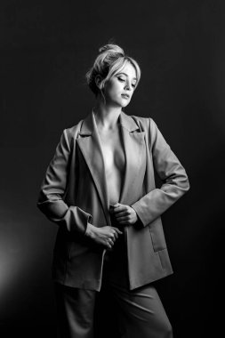 Seksi genç bir sarışın, çıplak bir bedenin üzerine giymiş bir ceket. Model aşağı bakıyor..