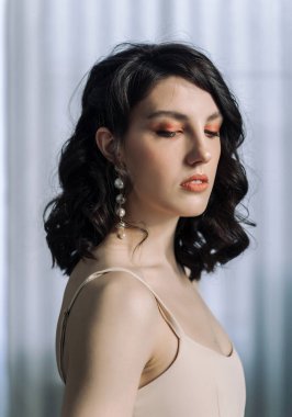 Güzel bir esmerin stüdyo portresini kapat ve kameraya ağzı açık bak. Kahverengi gözler, genç ve narin.