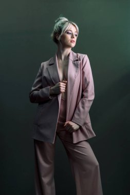 Seksi genç bir sarışın, çıplak bir bedenin üzerine giymiş bir ceket. Tarafsız bir bakış biraz yana..