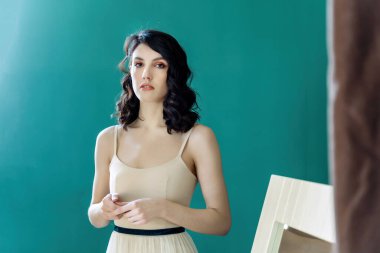 Zarif bayan portresi. Stüdyo yeşil arka planda izole edilmiş inci mücevher seti. Ellerini onun önünde tutuyor..