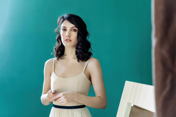 Elegant lady portrait.Pearls jewelry set posing isolated on studio green background. Holds his hands in front of him.