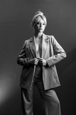 Seksi genç bir sarışın, çıplak bir bedenin üzerine giymiş bir ceket. Tarafsız bir bakış biraz yana..