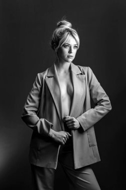 Seksi genç bir sarışın, çıplak bir bedenin üzerine giymiş bir ceket. Manken yana bakıyor..