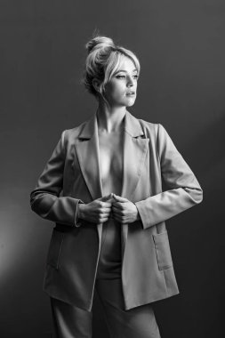 Seksi genç bir sarışın, çıplak bir vücut giymiş bir ceket..