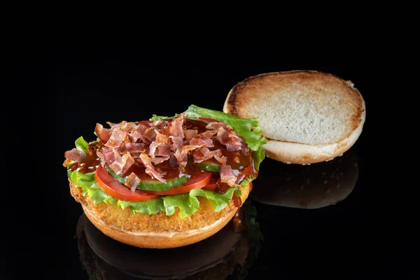 Бекон сирний гамбургер ізольований на чорному. Соус барбекю і салат . — стокове фото