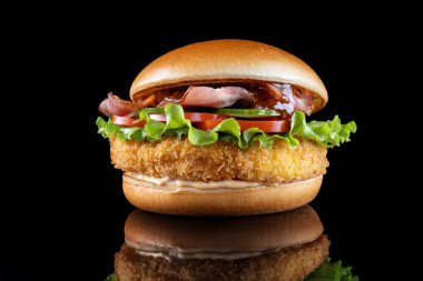 Siyah üzerine izole edilmiş pastırmalı çizburger. Barbekü sosu ve marul..