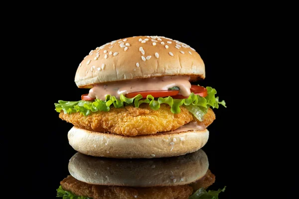 Hamburguesa con chuleta de pollo, ensalada y mayonesa. Sobre un fondo negro reflejado. Vista frontal —  Fotos de Stock