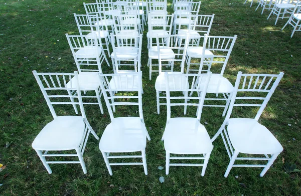 Witte bruiloft stoelen op een groene gazon, zonder decoratie. — Stockfoto