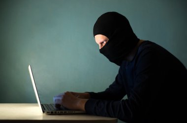Hacker maskeli bir dizüstü bilgisayar ile