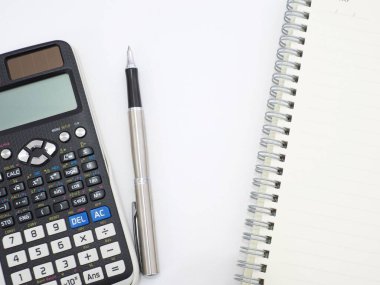 Beyaz arkaplan resmi üzerine bilimsel hesap makinesi kalem ve not defteri.