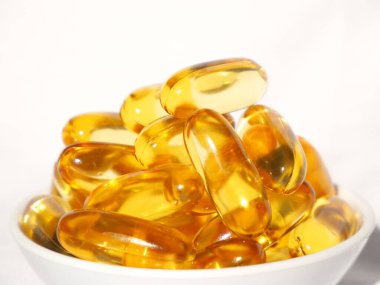 Omega-3 karaciğer yağı beyaz bir kabın içinde ve beyaz bir arkaplan resmiyle.