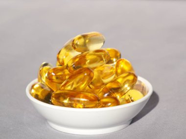 Omega-3 karaciğer yağı beyaz bir kabın içinde ve beyaz bir arkaplan resmiyle.