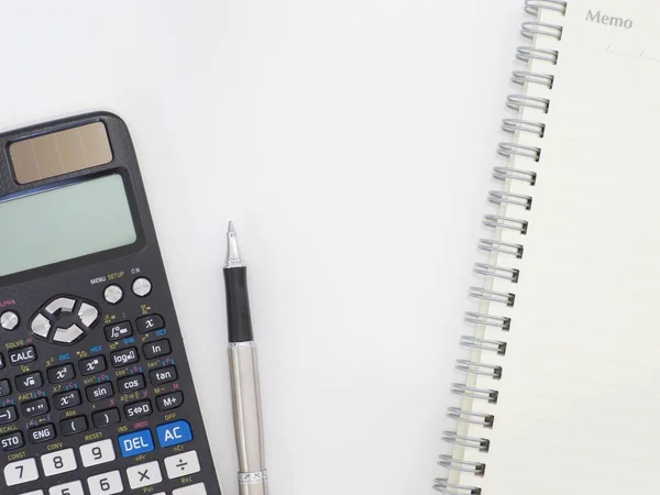 Scientific calculator pen and notepad on white background picture.