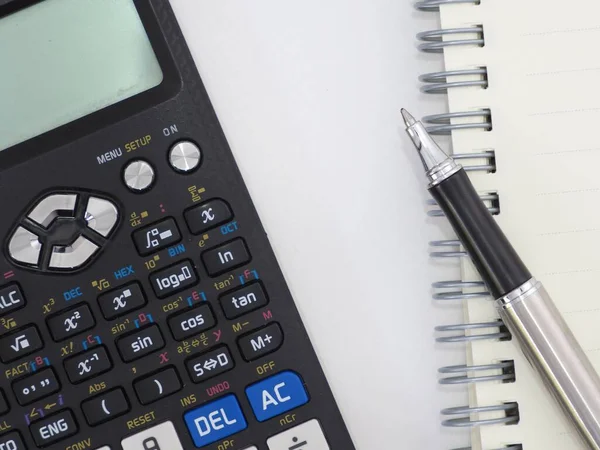 Bilimsel hesap makinesi kalem defteri ve ahşap bir arka planda vernier kalibre..