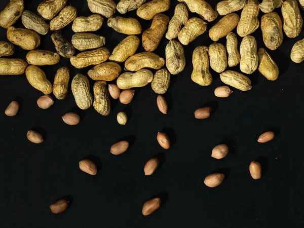 roasted peanuts on a black background