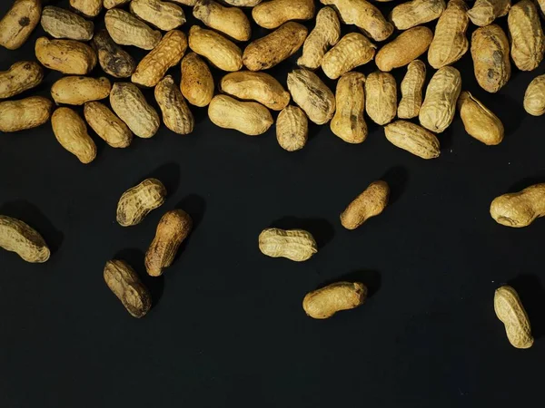 roasted peanuts on a black background