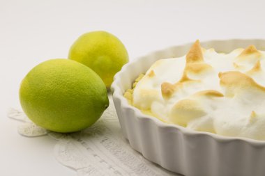 Lemon meringue pie and whole lemons on white clipart