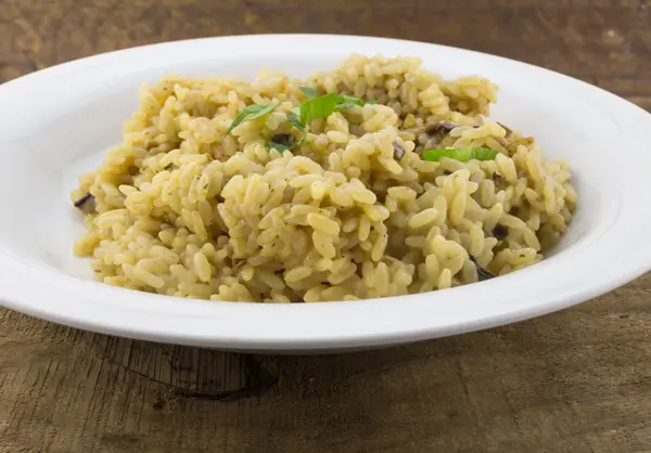 Pilzrisotto in Nahaufnahme auf weißem Teller auf Holz — Stockfoto