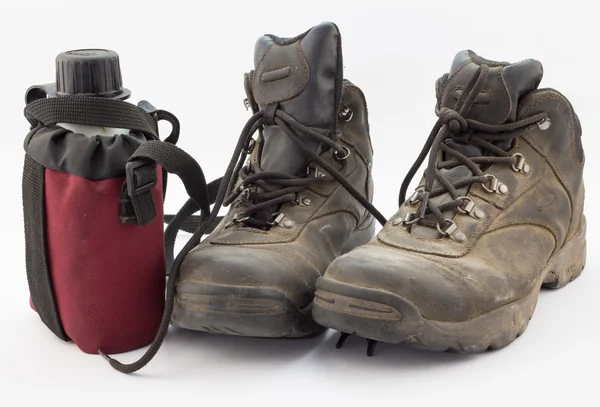 Dusty hiking boots and red water bottle — Stock Photo, Image