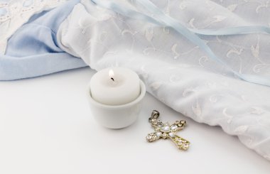 Arka plan ile çapraz kolye, mum ve mavi bebek vaftiz 