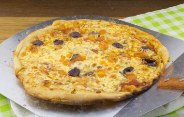 Zeytin ve hamsi pizza üzerinde metal spatula