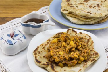 Nohut ve mercimek roti ve beyaz dantel üzerinde Hint turşusu ile köri