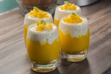 Bardakta mango tatlısı baharatlı krema ve mutfakta nane şekeri süslemesi.