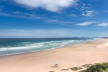 Bir yaz sabahı Port Elizabeth yakınlarındaki Maitland ağzındaki boş sahil manzarası, temiz ve mavi su ve gökyüzü. Büyük bir plajı var ve arka planda Doğu Cape Güney Afrika 'daki Jeffreys Körfezi ve St. Frances Körfezi' ne doğru uzanan