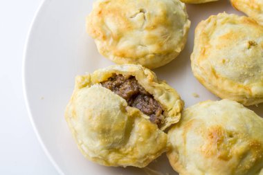 Tabakta biftekli turtalar. Beyaz arka planda, fotokopi alanı olan mini etli turtalar.