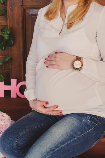 Mulher grávida abraça sua barriga. — Fotografia de Stock