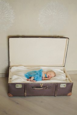 Bir bavulun içinde dikey şirin yeni doğan bebek uyuyor
