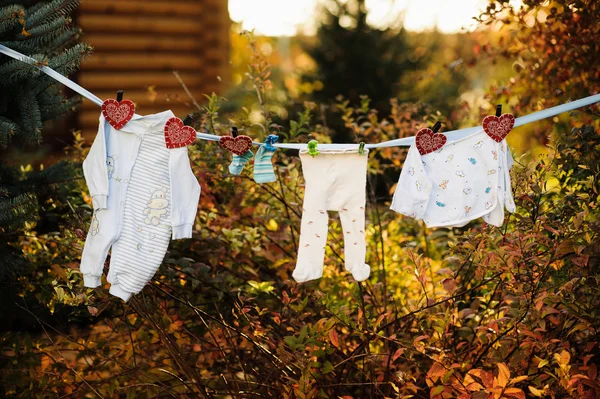 Asılı ve dryingon içinde açık bir clothesline bebek giysileri vardır