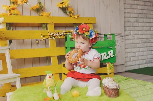 Child in Ukrainian national costume with Easter cake. Text happiness.