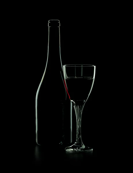 Μπουκάλι κόκκινο κρασί με το ποτήρι πάνω σε μαύρο φόντο — Φωτογραφία Αρχείου