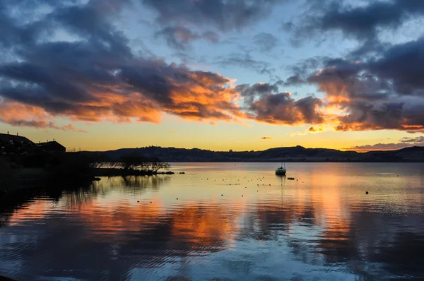 Farbenfroher Sonnenuntergang mit einem Boot im See Taupo, Neuseeland — Stockfoto