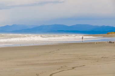 Hokitika, Yeni Zelanda gün batımında çalışan çocuk