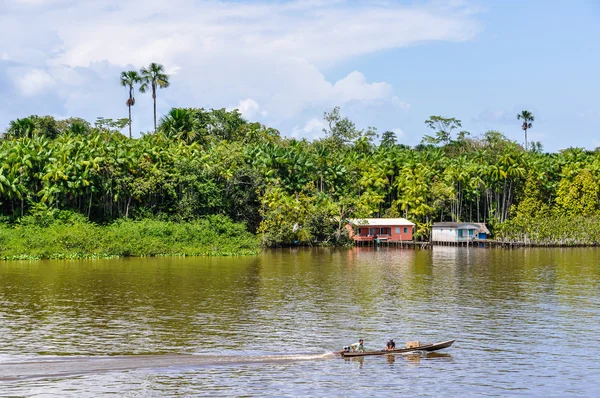 Barco local e uma casa no Rio Amazonas, Brasil — Fotografia de Stock