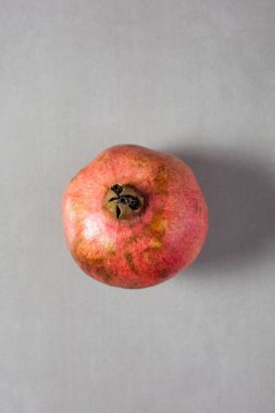 Gri arkaplanda dikey fotoğrafın ortasında kırmızı bir leke var. Minimalizm. Üst görünüm