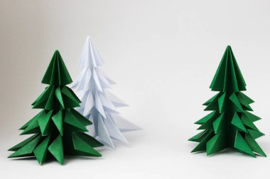 İki origami yeşil noel ağacı ve beyaz arka planda beyaz olan..